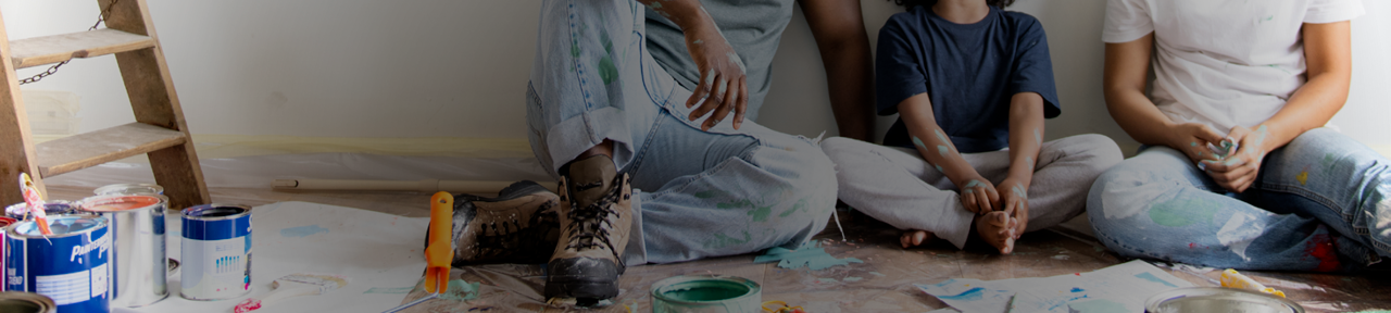 Family Sitting on Floor After Painting Room