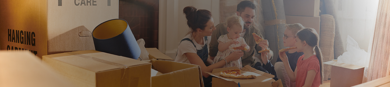 Family Eating Together on Cardboard Box During Move