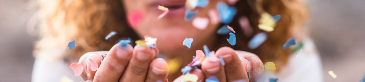 Person Blowing Colourful Confetti at Camera