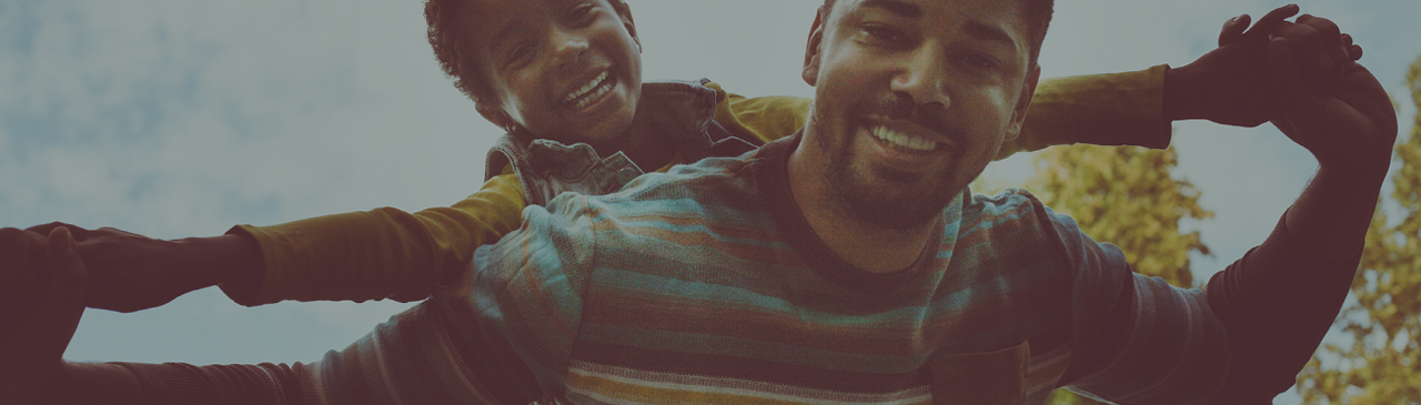 Father and Son Smiling While Playing Outside