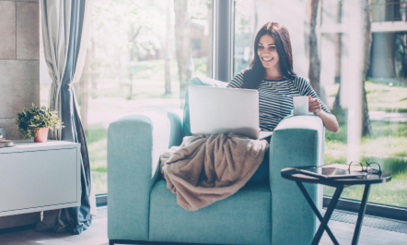 Woman Lounging on Chair with Coffee and Laptop