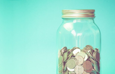 Savings Jar of Change on Turquoise Background