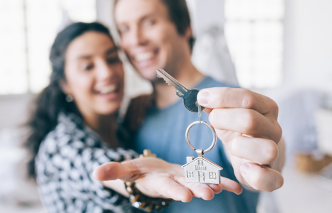Couple Holding Keys to First Home