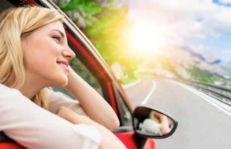 Woman Smiling While Looking Out Car Window