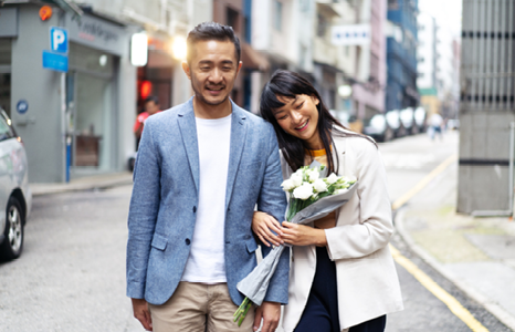 Couple Smiling While Walking Down the Street