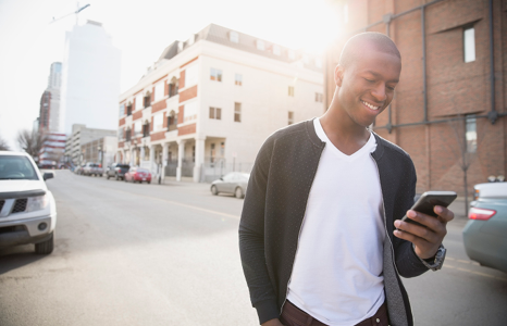 Man using FirstOntario Mobile App Walking Down Street