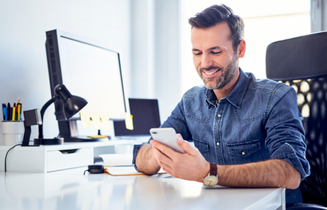 Man Smiling while using FirstOntario Mobile App in Office