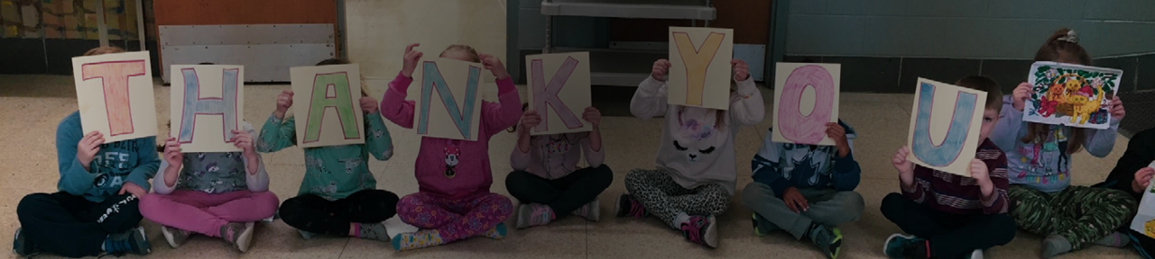 Group of Kids Holding Homemade Signs Spelling Out Thank You