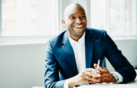 Man in Blue Suit Smiling in a Bright Room