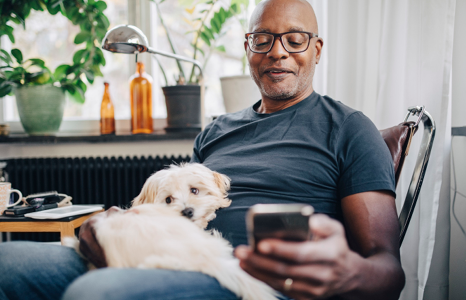 Man with a dog looking at his phone