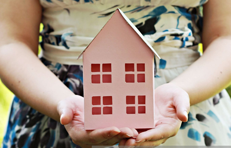 Woman Holding Pink House Made of Craft Paper