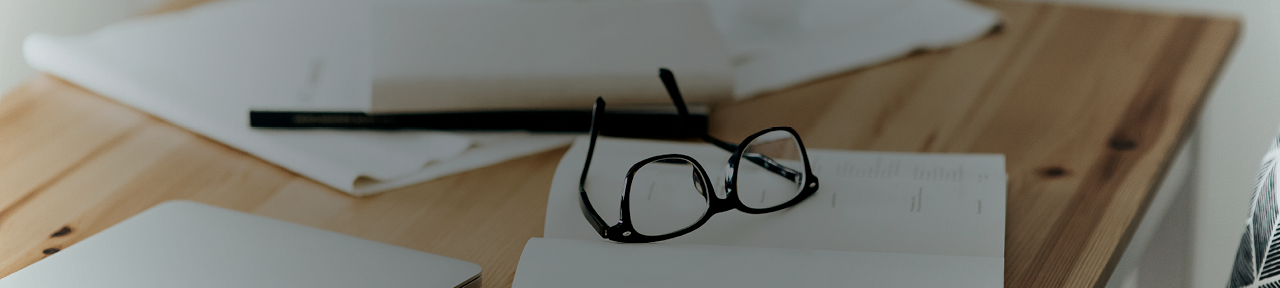 Wooden Desk with Papers and Glasses