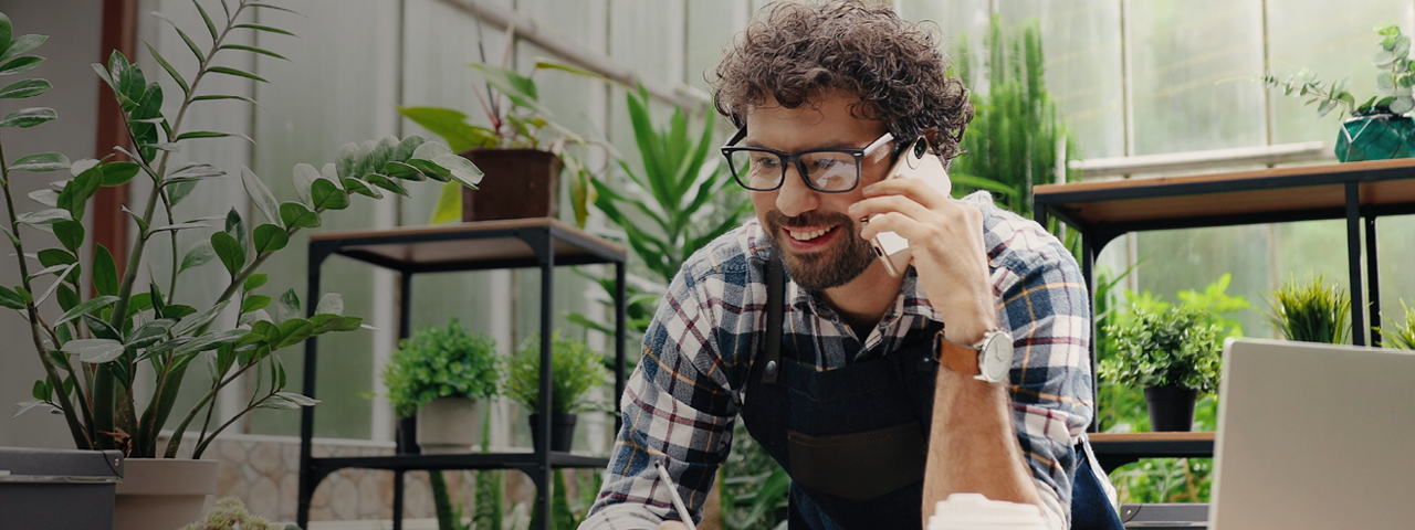 Person Talking on the Phone in Greenhouse