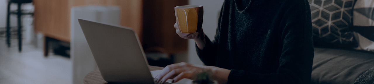 Person Drinking From Mug at Laptop