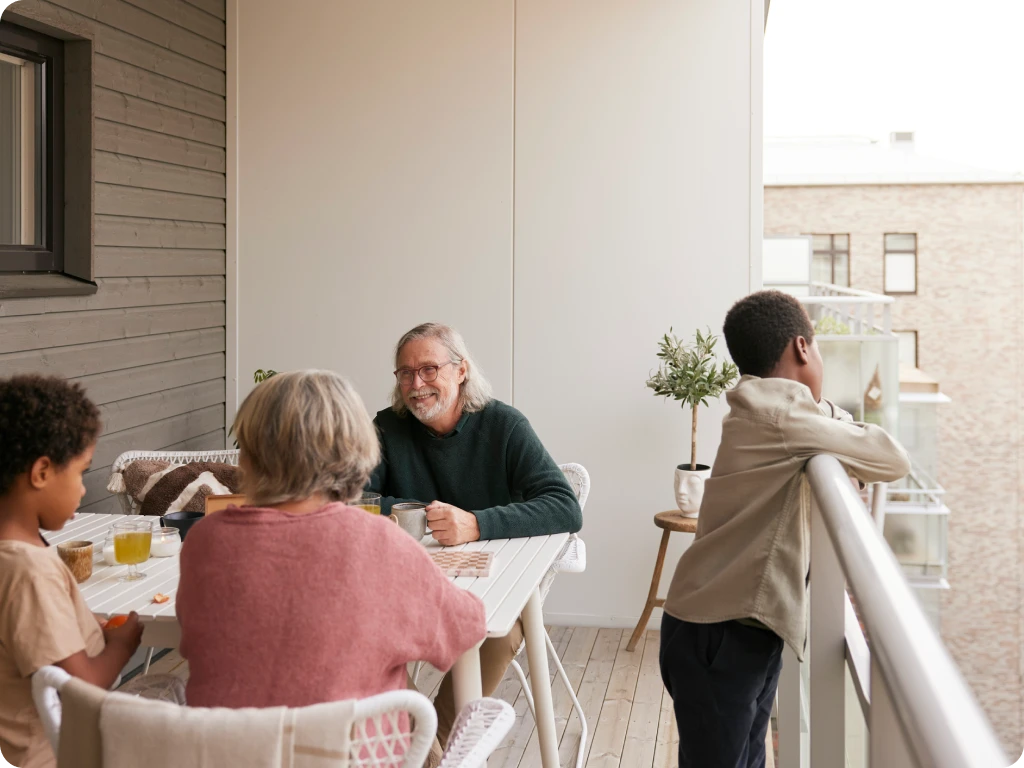 Family Smiling While Sitting Together on Condo Balcony