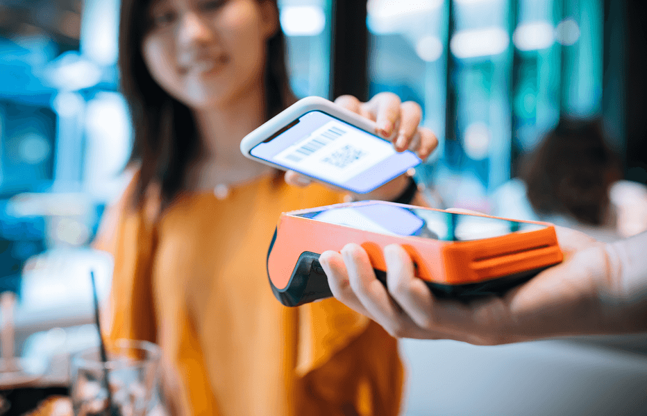 Woman Using Phone to Pay for Purchase on Smart Terminal