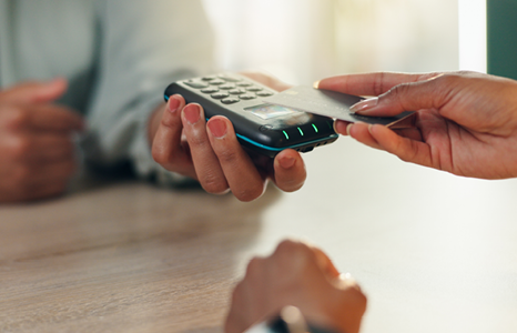 Person tapping debit card at POS machine