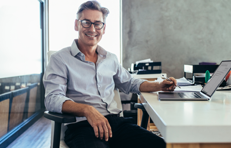 Business owner smiling while sitting at desk in office