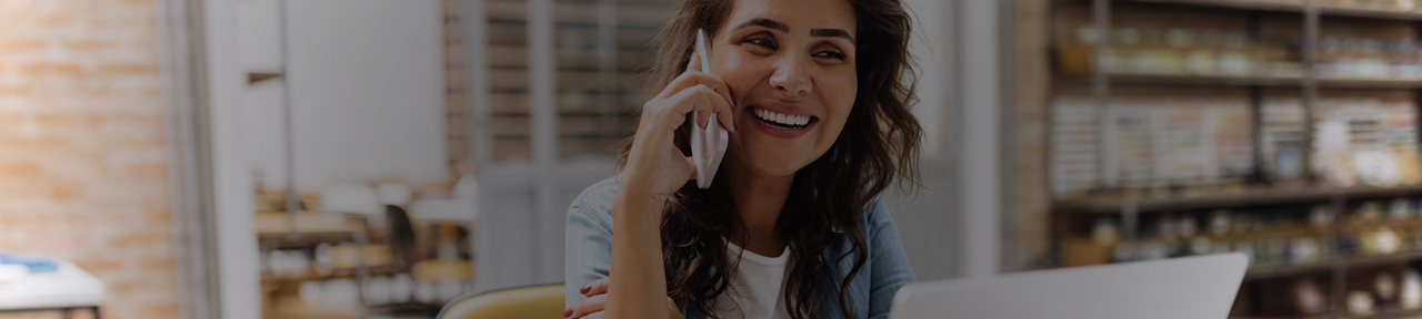 Woman Smiling While Talking to Member Solutions Team Over the Phone