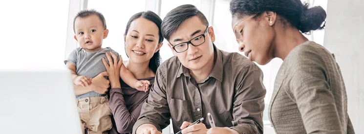 Family with baby meeting with financial advisor to discuss investments