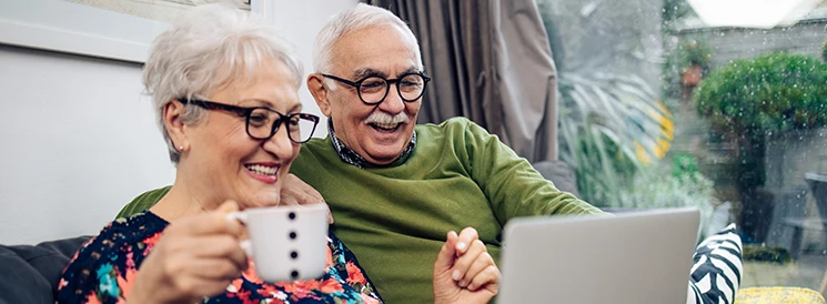 Elderly couple smiling while reviewing their retirement savings