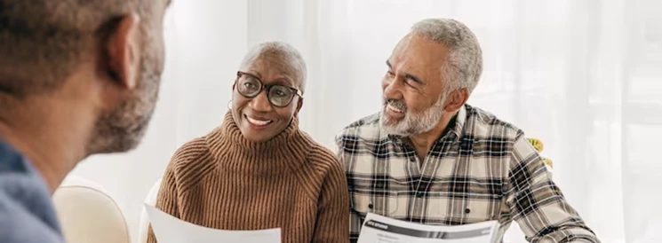 Couple smiling while meeting with lawyer about their will