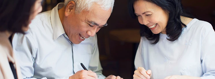 Couple smiling while signing power of attorney documents