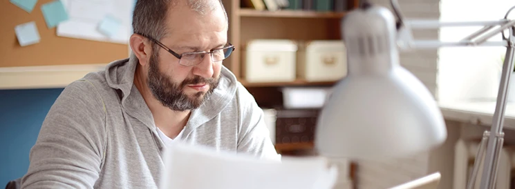 Man reviewing joint account paperwork at desk