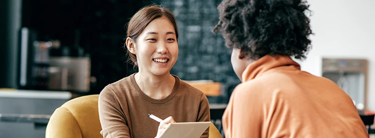 Two students meeting and taking notes