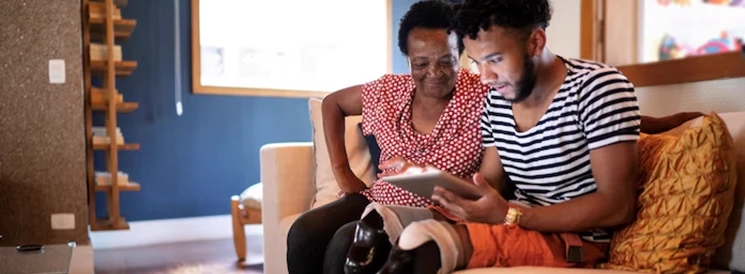 Mother and son sitting on couch reading about RDSPs