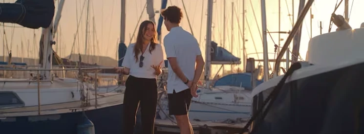 Couple standing on dock in marina at sunset