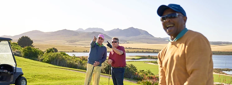 Three men playing golf on sunny day