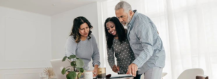 Family gathering around kitchen table to review financial documents