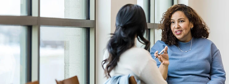 Two women discussing financial goals in an office