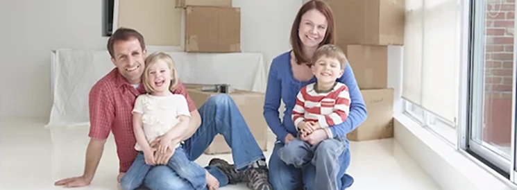 Family smiling together in living after moving in