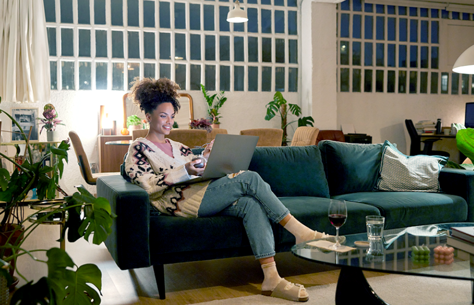 Person Sitting on Couch Using Laptop