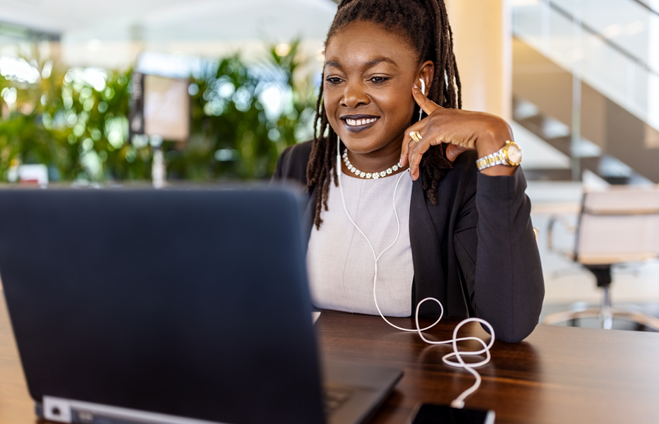 Woman Smiling Using Laptop in Office Library