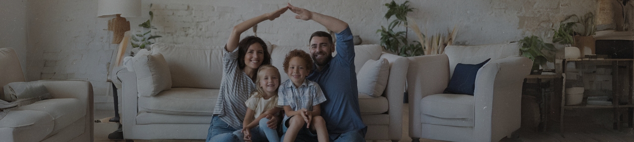 Family of four sitting together in the living room posing for family picture