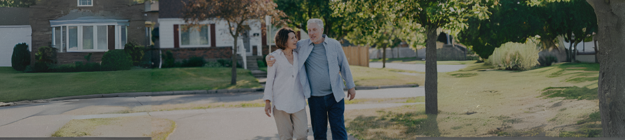 Retired couple walking down the street in suburban neighbourhood