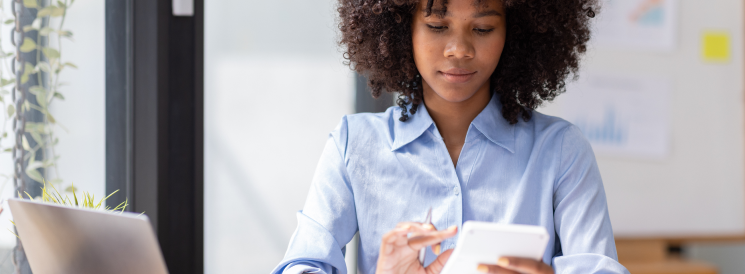 Woman doing calculations on calculator at desk