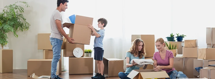 family of four moving into new home surrounded by moving boxes