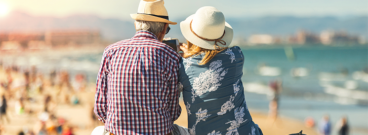 Retired couple looking at the ocean on the beach