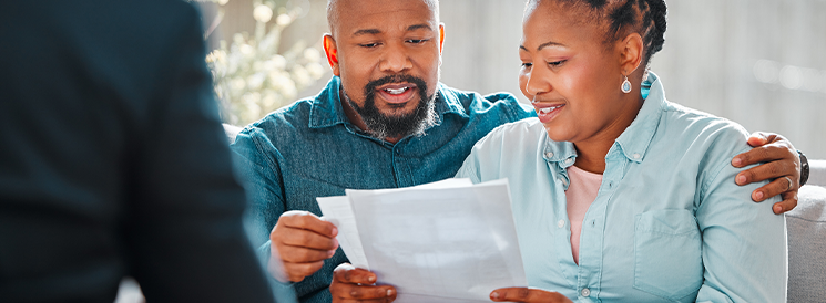 Couple reviewing financial documents with advisor