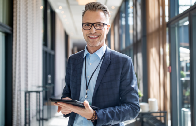 Financial Advisor Smiling and Holding Tablet