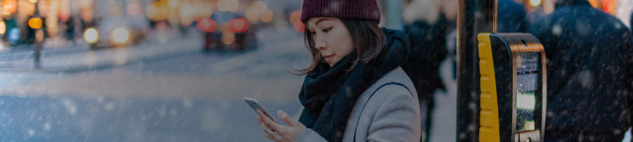 Woman Waiting to Cross Street Holding Phone