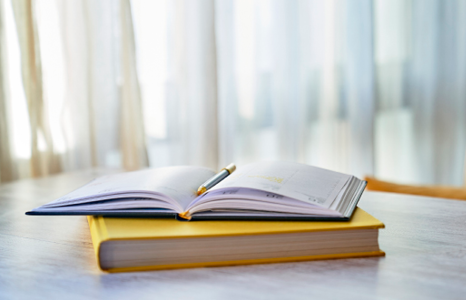 Open Notebook and Textbook on Desk