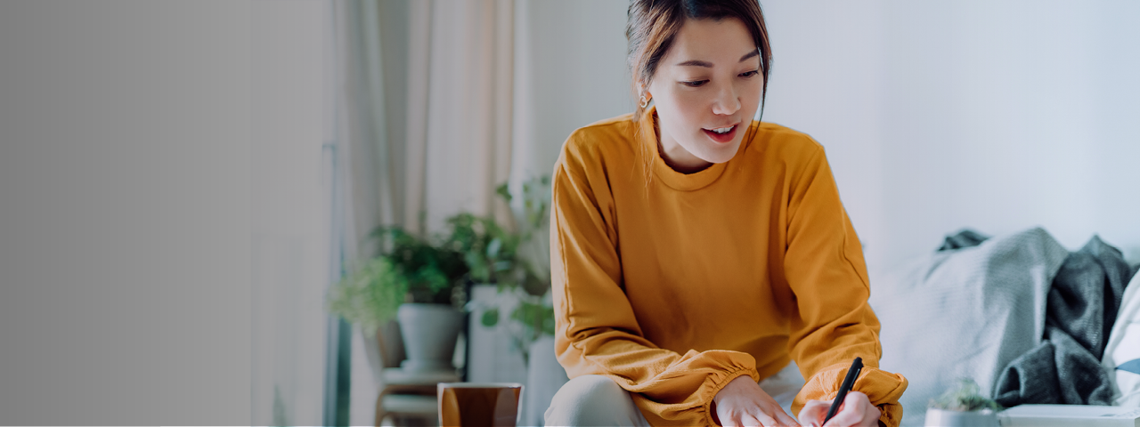 Woman Writing Notes While Watching Webinar