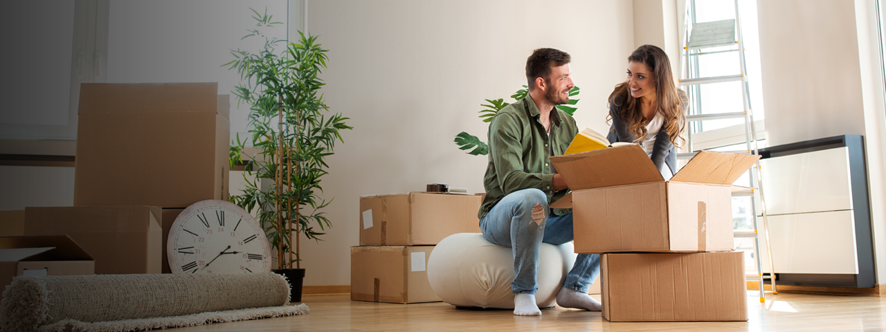 Couple unpacking moving boxes in new living room