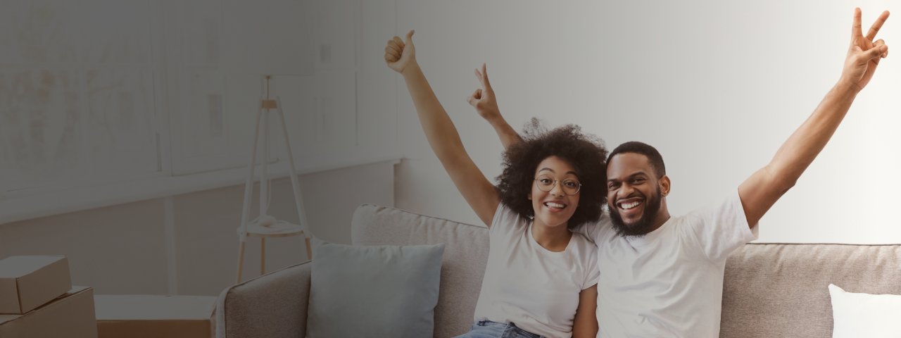 Smiling couple celebrating a move to their new home
