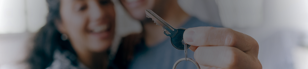 Couple holding key to new house obtained through a FirstOntario mortgage